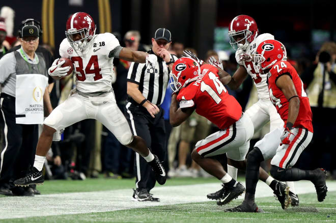 Alabama Crimson Tide running back Damien Harris (34) runs the ball against Georgia Bulldogs defensive back Malkom Parrish (14) during the second quarter in the 2018 CFP national championship college football game at Mercedes-Benz Stadium.