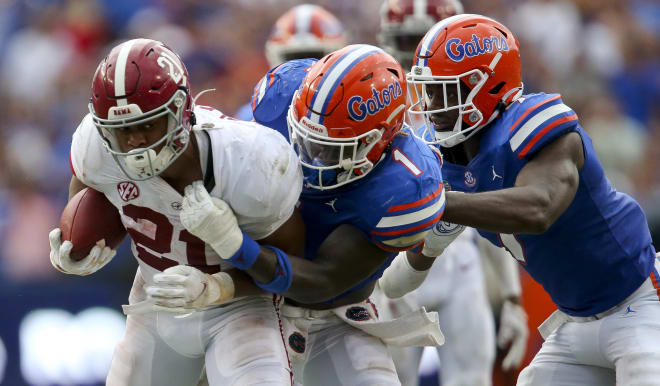 Alabama running back Jase McClellan (21) is brought down by Florida linebacker Brenton Cox Jr. (1) and Florida linebacker Jeremiah Moon (7) at Ben Hill Griffin Stadium. Photo | USA TODAY