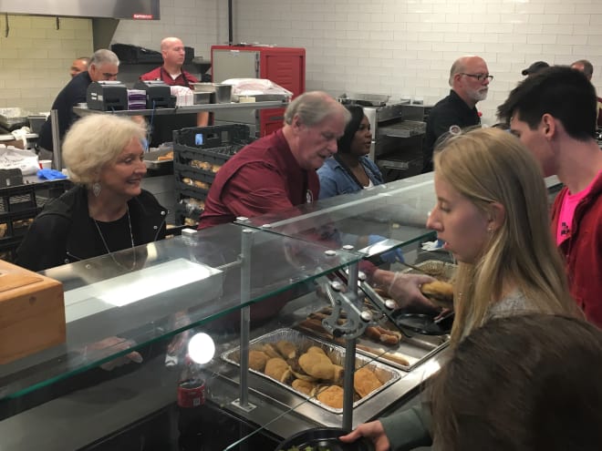 FSU President John Thrasher (middle) and his wife, Jean (left), serve students during Monday's free dinner inside Doak Campbell Stadium.
