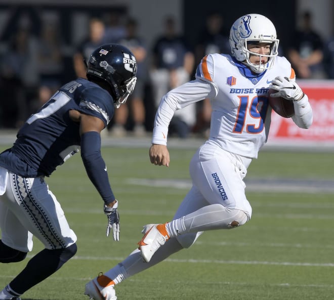 Boise State quarterback Hank Bachmeier (19) runs with the ball as Utah State safety Hunter Reynolds (27) defends during the first half of an NCAA college football game Saturday, Sept. 25, 2021, in Logan, Utah.