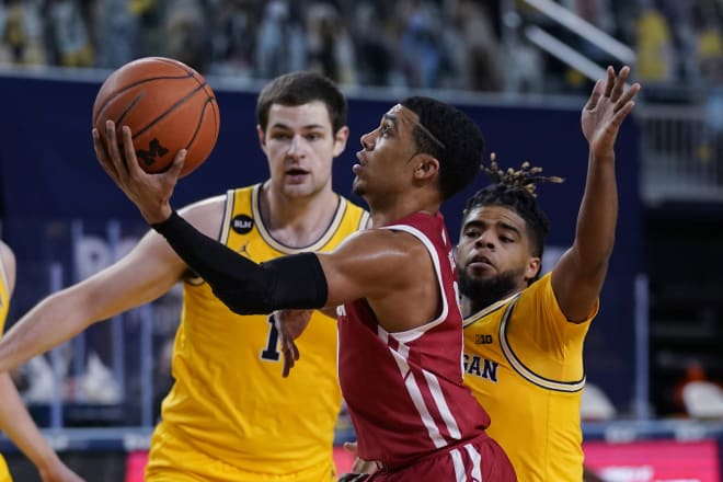 Wisconsin guard D'Mitrik Trice is defended by Michigan center Hunter Dickinson (1) and guard Mike Smith.