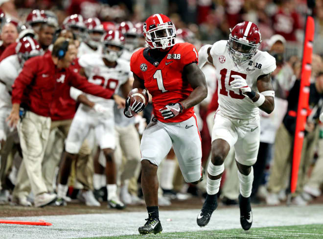 Georgia Bulldogs running back Sony Michel (1) runs the ball against Alabama Crimson Tide defensive back Ronnie Harrison (15) in the 2018 CFP national championship college football game at Mercedes-Benz Stadium. Photo | Getty Images 