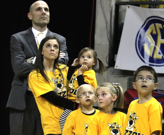 The Loos family waits courtside before Brad spoke to the crowd at halftime