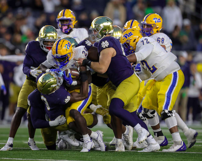 Linebacker Jaylen Sneed (3) and defensive lineman Donovan Hinish (right) help gang tackle Pitt running back C'Bo Flemister, who started his college career at Notre Dame.