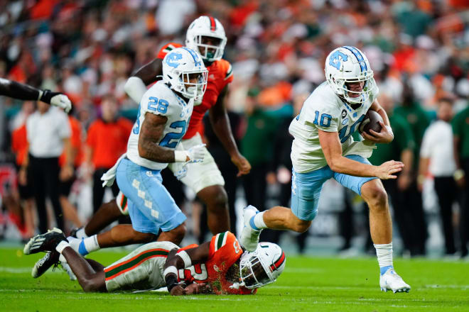Drake Maye, here at right running against Miami, has been fantastic for UNC. 