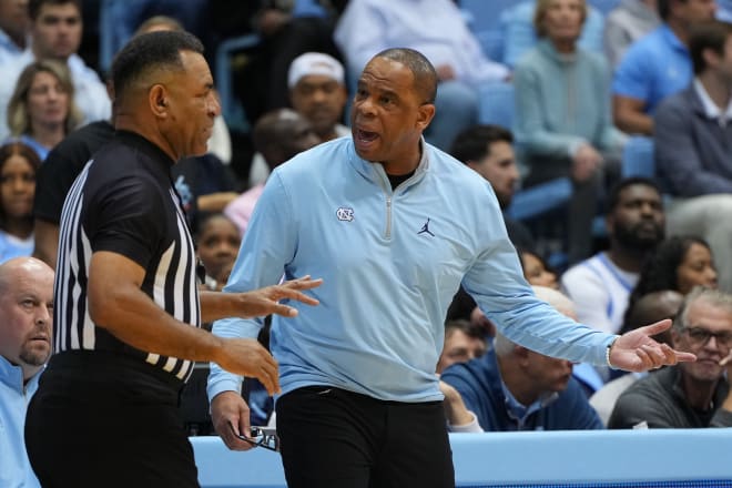 UNC coach Hubert Davis talks with referee Jeff Clark during a game against N.C. State a couple of weeks ago. 
