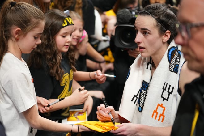Caitlin Clark signs autographs for young fans following Iowa's win over Colorado in the Sweet 16.