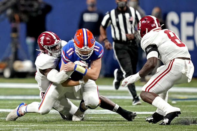 Florida Gators quarterback Kyle Trask (11) is tackled by Alabama Crimson Tide linebacker Will Anderson Jr. (31) and linebacker Christian Harris (8) during the first quarter in the SEC Championship at Mercedes-Benz Stadium. Photo | Imagn