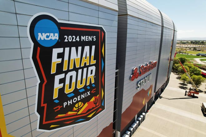 March 25, 2024; Glendale, AZ, USA; Workers install logos on the exterior of State Farm Stadium in preparations for the Final Four of the NCAA Tournament to be held from April 6-8. Mandatory Credit: Michael Chow-USA TODAY Sports