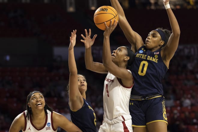 Oklahoma's Kennady Tucker (4) shoots a layup as Notre Dame's May Dodson (0) Anaya Peoples apply pressure in a second-round NCAA Tourney game, Monday night in Norman, Okla. 