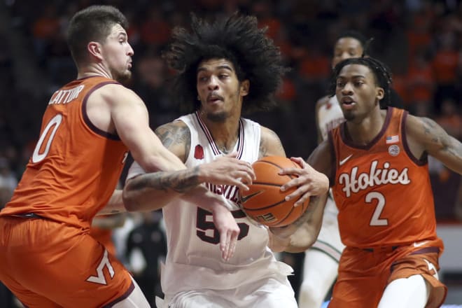 Louisville's Skyy Clark (55) is defended by Virginia Tech's Hunter Cattoor (0) and MJ Collins