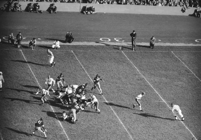 Fullback Alan Ameche of Wisconsin heads into strong side of the Northwestern line in first quarter of game at Evanston, Ill., Oct. 27, 1951, as his blockers open a spot in the other.