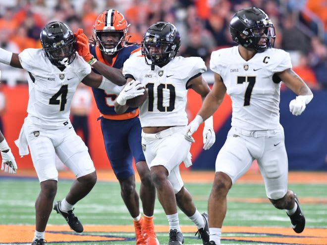 Black Knights CB Cameron Jones (10) returns an interception against the Syracuse Orange with help from CB Jabari Moore (4) and LB Jimmy Ciarlo (7) in the second quarter at the JMA Wireless Dome.