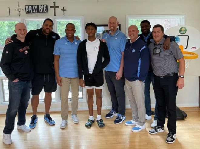 Simeon Wilcher posing with the entire North Carolina coaching staff 