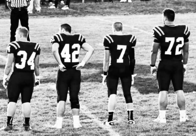 Simon Stepaniak (#72) and fellow captains for Ross High School football stand at midfield.