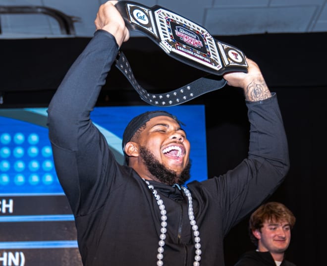 Offensive lineman TJ Session holds up a championship belt after one of this week's bowl events.