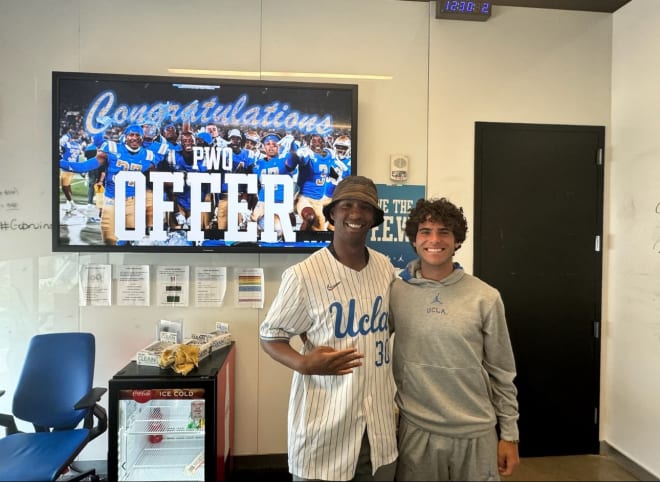 UCLA cornerbacks coach and special teams coordinator Kodi Whitfield, left, alongside 2025 Chatsworth (Calif.) Sierra Canyon kicker Ashton Zamani after a preferred walk-on offer was extended at Tuesday’s UCLA prospect camp.