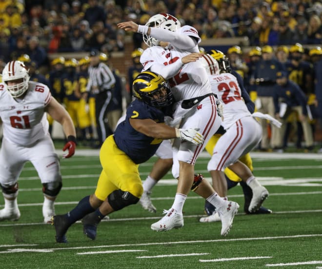 Michigan Wolverines football defensive tackle Carlo Kemp hits a quarterback