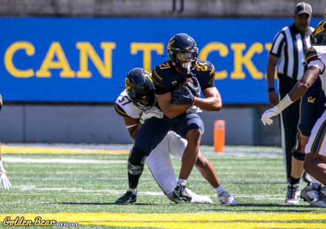 Running back Byron Cardwell is tackled by linebacker BJ Jones on a rush during Saturday's spring showcase.