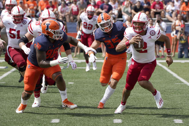 Nebraska quarterback Adrian Martinez running from Illinois LB Jake Hanson (35) and DL Keith Randolph Jr (88)