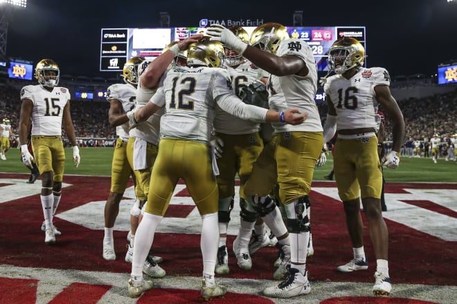 QB Tyler Buchner (12) and the Notre Dame offense celebrate an Irish touchdown in their Dec. 30 Gator Bowl in over South Carolina.