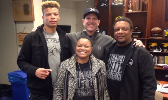 Woods with his parents and U-M head coach Jim Harbaugh