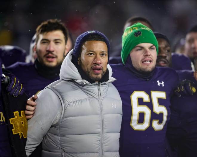 Marcus Freeman signs the Notre Dame Alma Mater with his players after ND's 44-0 win over Boston College on Saturday.