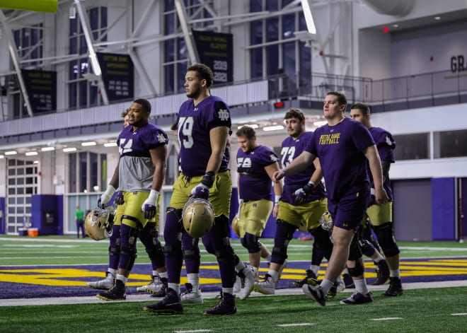 Junior Tosh Baker (79) and fellow Notre Dame offensive linemen make their way to the practice field.