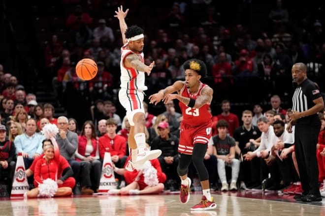 Chucky Hepburn passes around Ohio State Buckeyes guard Roddy Gayle Jr. in Wednesday's UW win .