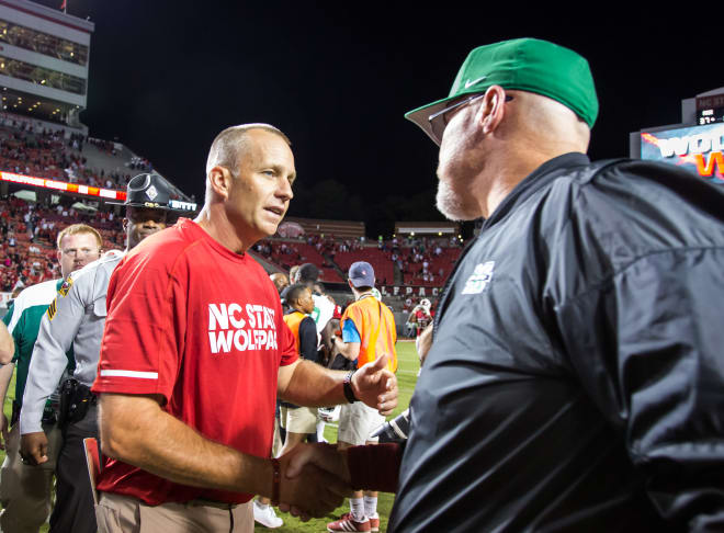 Doeren shakes hands with Marshall coaches after the game.