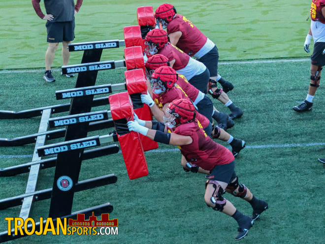 The USC offensive line pushes the blocking sled during practice Wednesday morning.