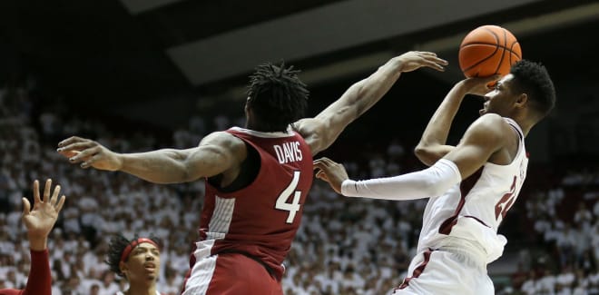Arkansas guard Davonte Davis (4) attempts to block as shot by Alabama forward Brandon Miller (24) at Coleman Coliseum. Alabama prevailed with an 86-83 victory.