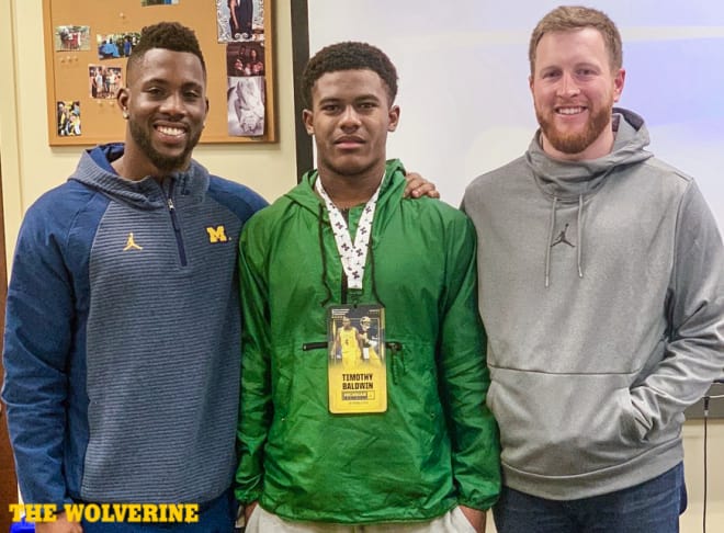 Three-star running back Tim Baldwin looks happy between running back coaches Jay Harbaugh and Alfonso Smith.