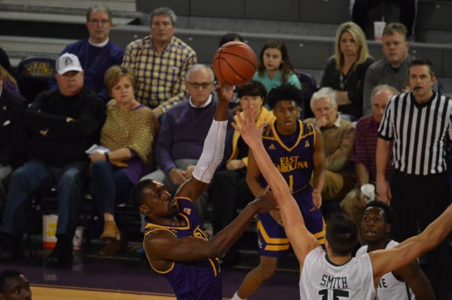 ECU's Michel Nzege shoots over Tulane's Ryan Smith in the Pirates' 74-65 win over the Green Wave.