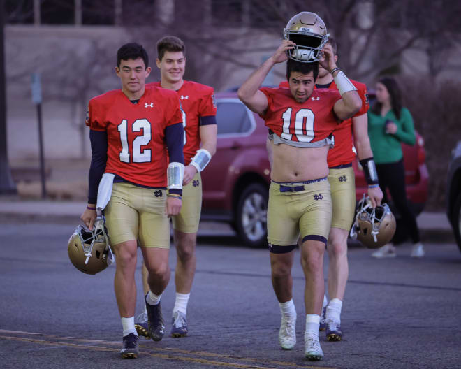 Notre Dame quarterbacks Tyler Buchner (12), Drew Pyne (10), Steve Angeli (back left) and Ron Powlus III )back right) arrive for practice.