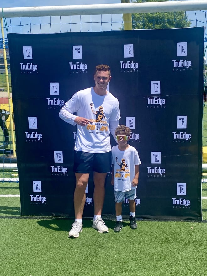Brady Cook takes a picture with a young camper.