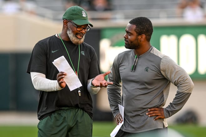 Michigan State running backs coach Effrem Reed (right) talks with tight ends coach Ted Gilmore (left) on Aug. 23, 2021.  