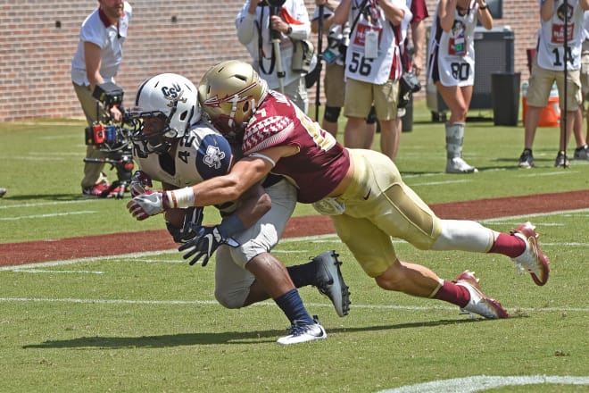 Jared Jackson wraps up a Charleston Southern player earlier this season.