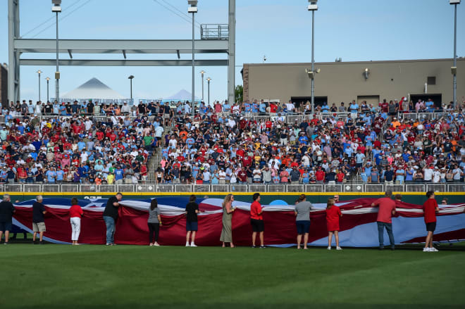 An American flag covers the outfield before a game between the Oklahoma Sooners and the Ole Miss Rebels at Charles Schwab Field. Mandatory Credit: Steven Branscombe-USA TODAY Sports