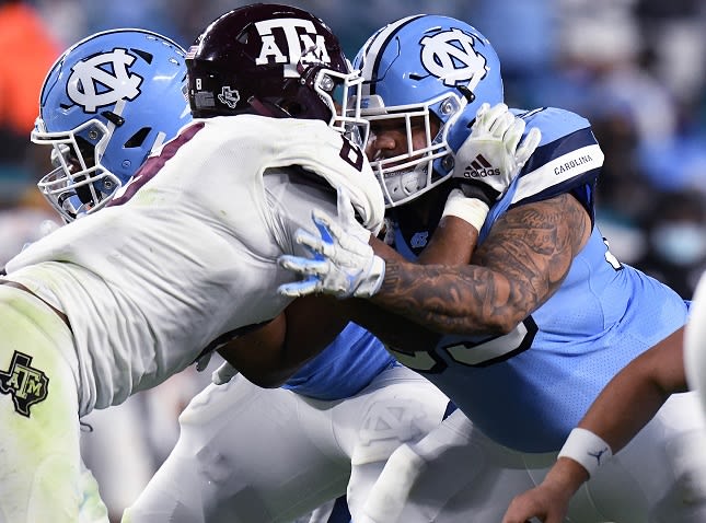 Quiron Johnson (right) was awarded a scholarship by UNC Coach Mack Brown last January. 