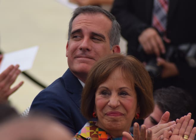 Los Angeles Mayor Eric Garcetti and USC President Carol Folt applaud during the Coliseum unveiling ceremony.