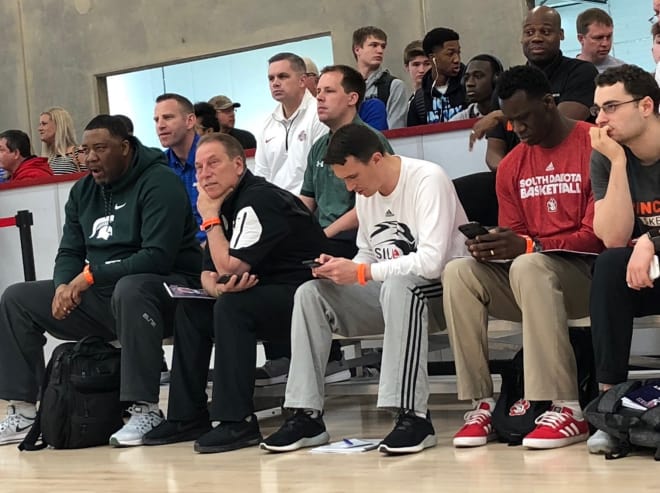 Tom Izzo, Chris Holtmann and other coaches take in the action.