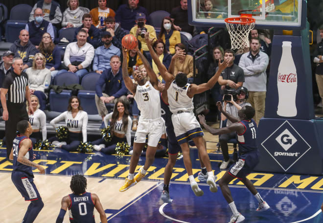 West Virginia Mountaineers forward Gabe Osabuohien (3) grabs a rebound during the first half against the Connecticut Huskies at WVU Coliseum.
