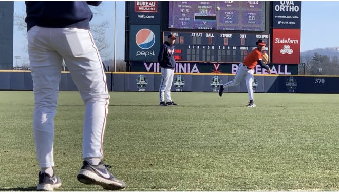 UVa pitching coach Drew Dickinson watches as first-year pitcher Jay Woolfolk gets loose at practice on Tuesday.