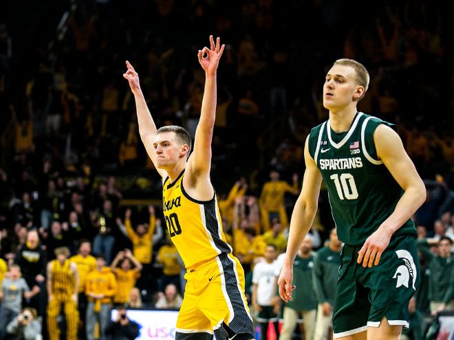 Iowa's Payton Sandfort celebrates after making a 3-point basket as Michigan State's Joey Hauser defends