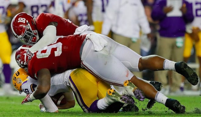 Dylana Moses (18) and Da'Ron Payne (94) combine to sack LSU quarterback Danny Etling. Photo | Getty Images