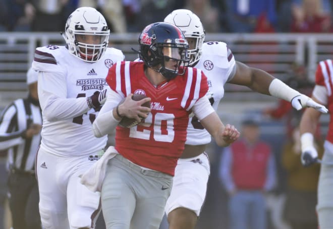 Ole Miss quarterback Shea Patterson runs away from a pair of Mississippi State defenders Saturday in Oxford. Patterson threw for 320 yards and ran for 73 more in the Rebels' 55-20 loss.