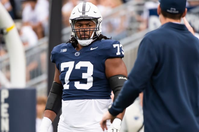 Penn State offensive lineman Caedan Wallace (73) listens to offensive line coach Phil Trautwein (right) during warmups in Beaver Stadium before an NCAA football game against Indiana Saturday, Oct. 28, 2023, in State College, Pa. The Nittany Lions won, 33-24.