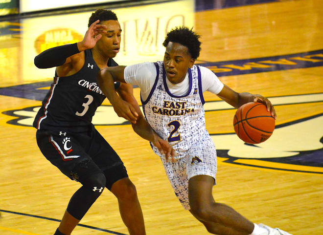 Tristen Newton drives on Mika Adams-Woods in ECU's 70-67 overtime loss to Cincinnati on Sunday in Greenville 