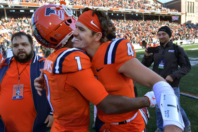 Nov 11, 2023; Champaign, Illinois, USA; Illinois Fighting Illini quarterback John Paddock (4) hugs wide receiver Isaiah Williams (1) after Paddock threw the winning pass to Williams in the end zone in overtime to defeat the Indiana Hoosiers at Memorial Stadium. Mandatory Credit: Ron Johnson-USA TODAY Sports